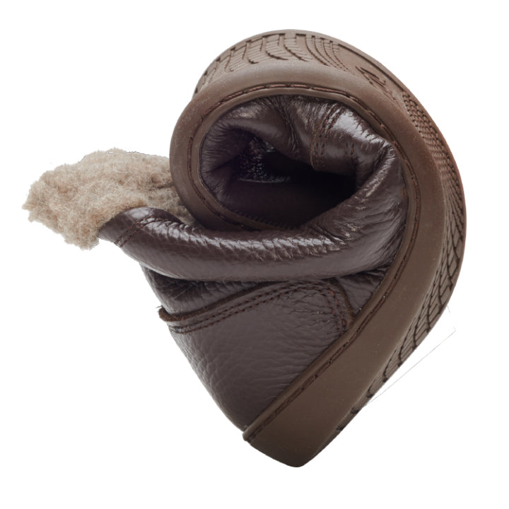 Läderskon PREQUEL Winter Nappa Brown från ZAQQ med mysigt inre är elegant spiralvriden och demonstrerar därmed sin flexibilitet och mjukhet mot en enkel vit bakgrund.