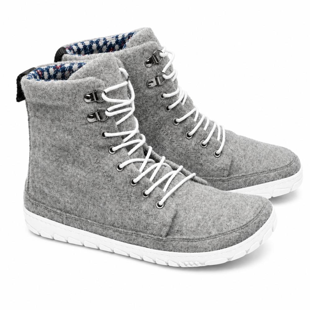 Vi presenterar QICE Grey från ZAQQ: ett stiligt par grå high-top-filt-sneakers med vita skosnören och robusta vita gummisulor. Dessa sneakers har en utomhussula för bättre grepp, komplett med metallöljetter och ett strukturerat mönster på yttersulan, vilket gör dem perfekta för varje äventyr.