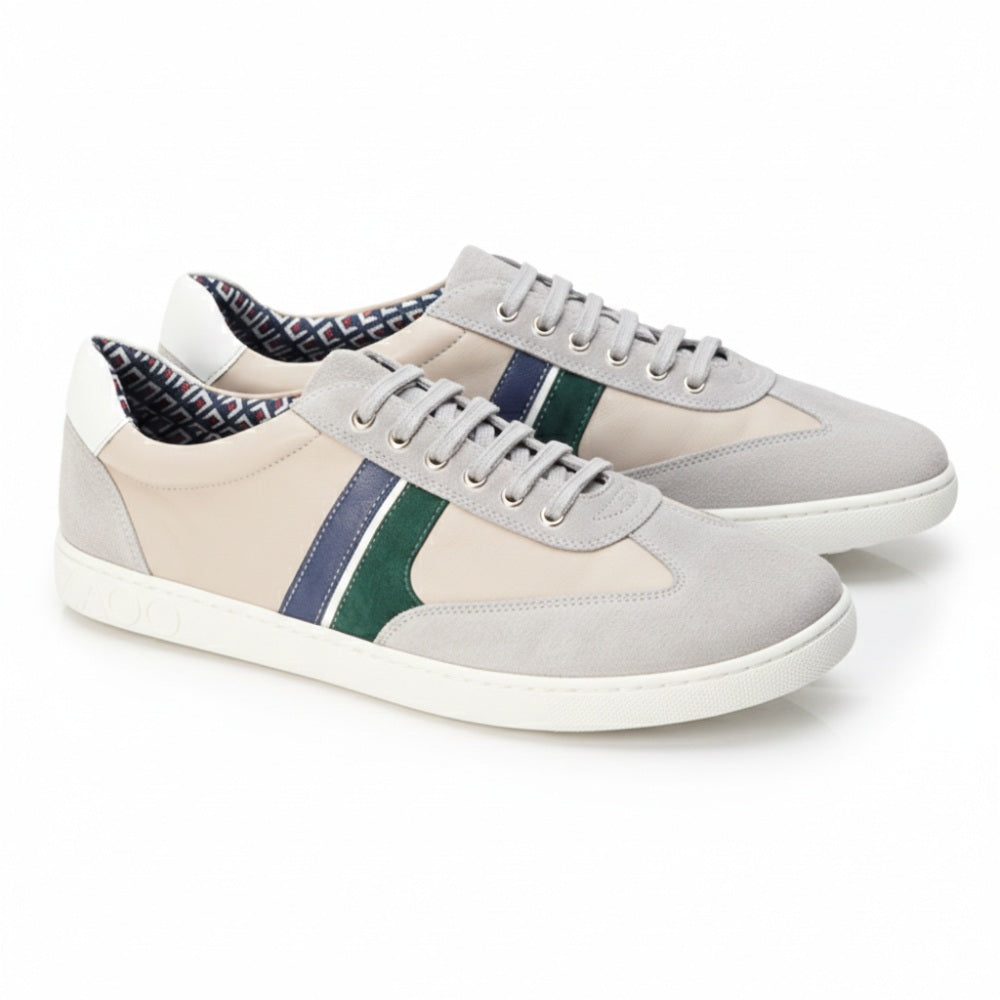 Wir präsentieren die QLAUDE Grey Sneaker von ZAQQ: Diese modischen Freizeitschuhe haben eine Außenseite aus hellgrauem Wildleder, die mit dunkelblauen und grünen Streifen verziert ist. Die Innenseite ist mit einem stilvollen Muster gefüttert, während die weiße ZAQQ Sneakersohle mit ihren dezenten dekorativen Texturen ein zeitgenössisches Flair verleiht. Ideal für jeden Anlass!