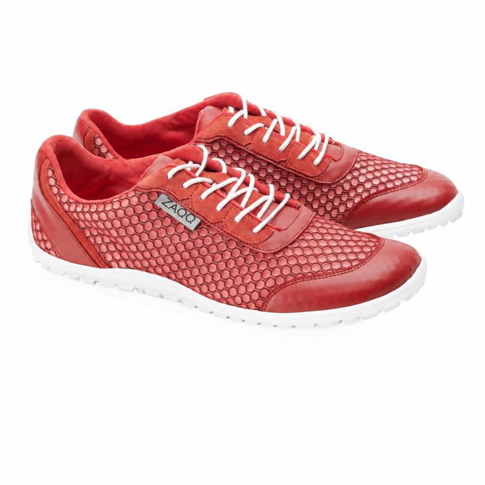 Ett par TOQIO Red-sneakers från ZAQQ, med ultramodern design med rött övermaterial, accentuerat av vita skosnören och sexkantiga mesh-detaljer. Dessa skor visar stolt upp en elegant vit sula och en märkeslogga på sidan, elegant placerade bredvid varandra på en fläckfri vit bakgrund.